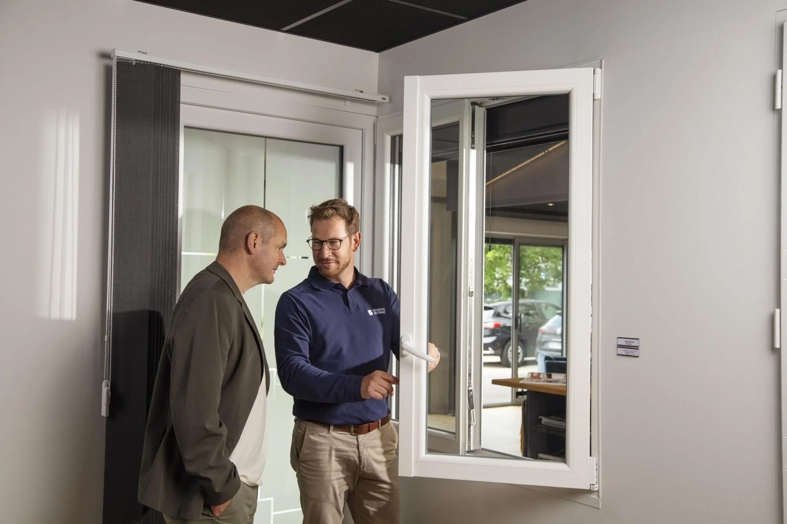 Conseiller de vente en menuiserie présentant des produits à un client dans un showroom